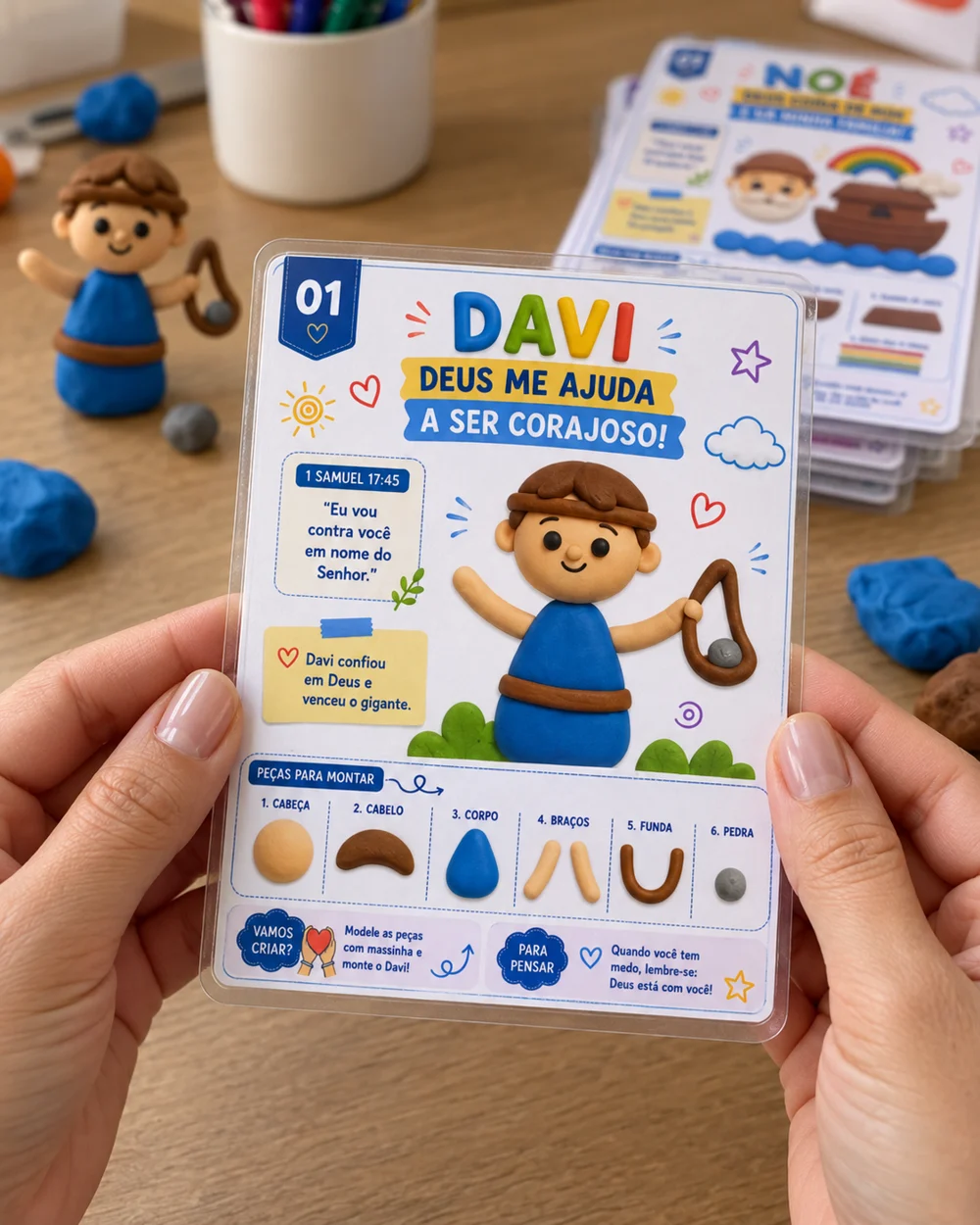 Detalhe ilustrativo de card de Davi plastificado nas mãos